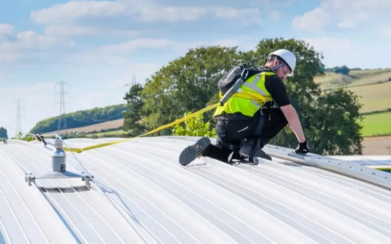 Operative clipped to a Latchways Constant Force post lifeline on a profiled metal roof