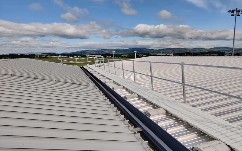 Rooftop walkway with adjacent guardrail providing a protected access route